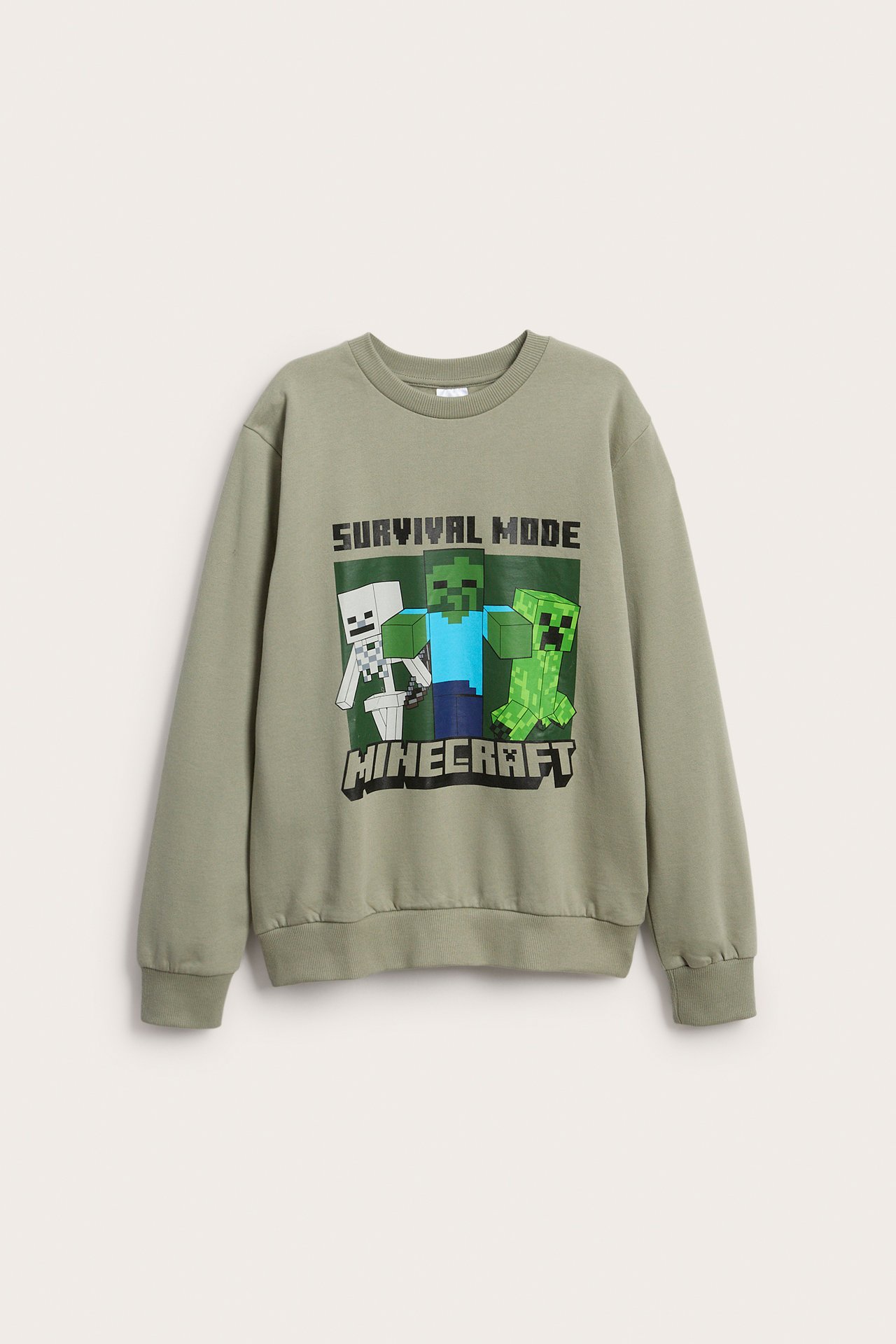 Edestä näkymä lasten salviavihreästä pitkähihaisesta collegepaidasta, jossa on Minecraft 'Survival Mode' -printti.