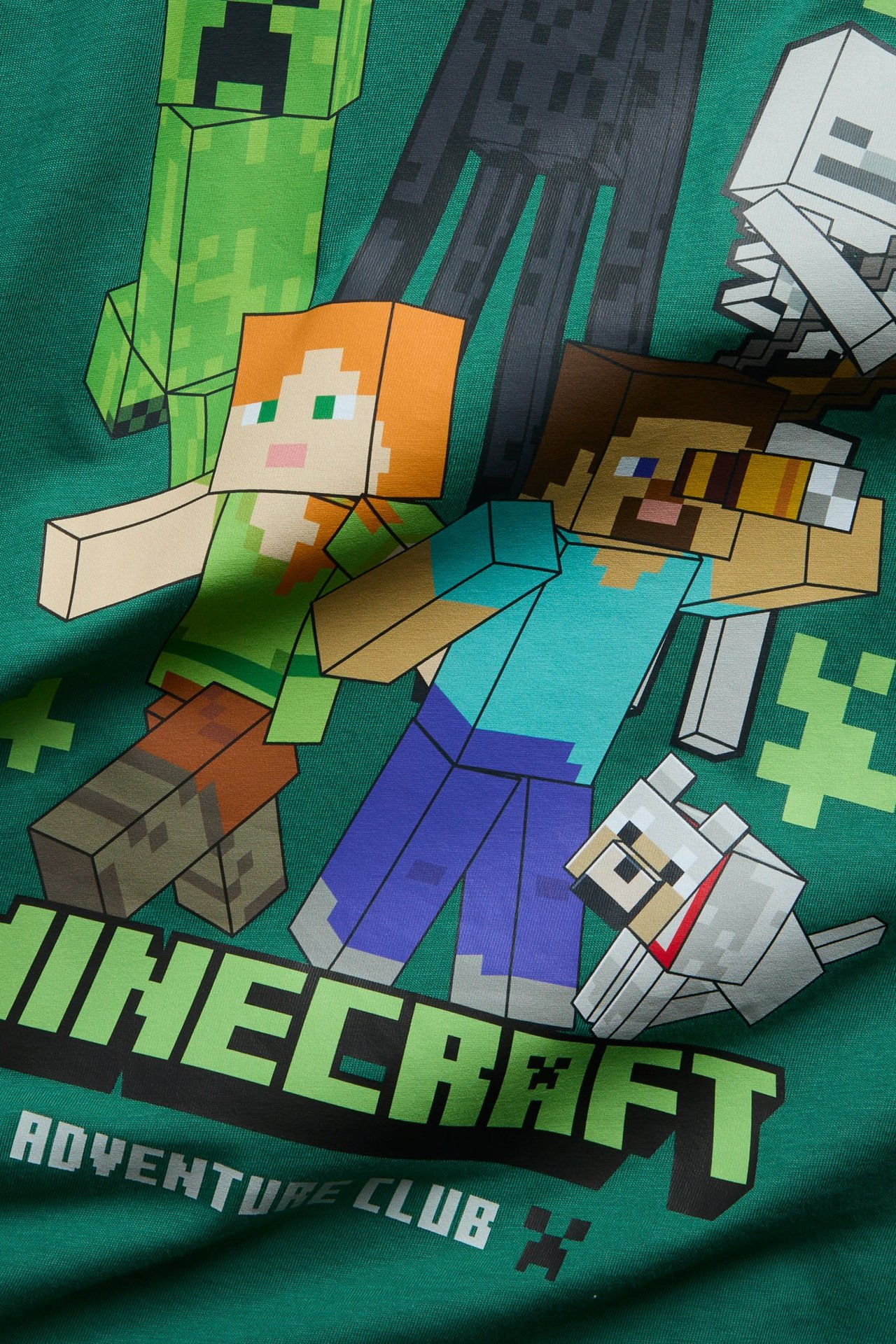 Zbliżenie na zielony t-shirt z kolorowym nadrukiem postaci Minecraft na przodzie.