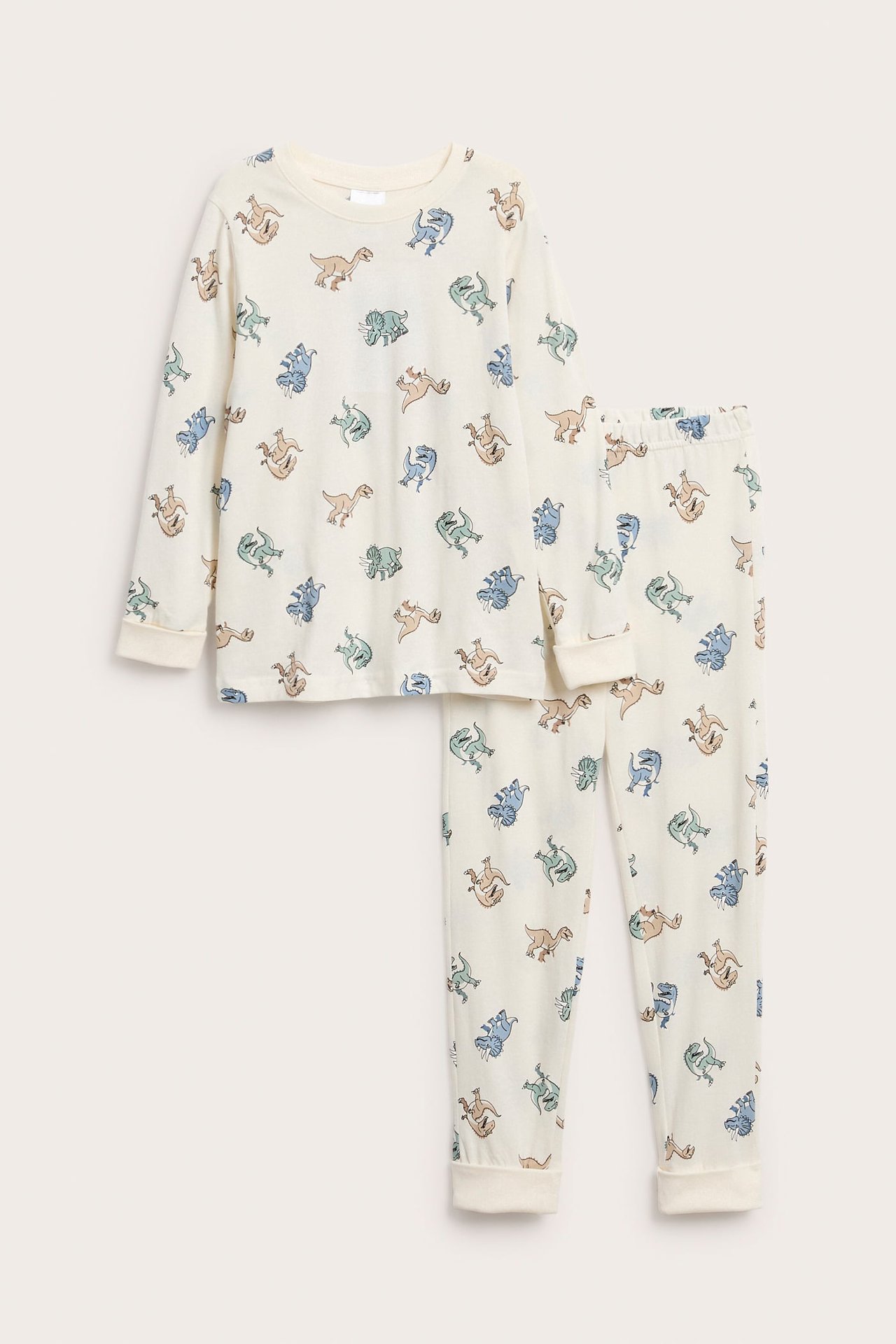 Lasten luonnonvalkoinen puuvillatrikoopyjama värikkäällä dinosauruskuviolla ja pitkillä hihoilla.