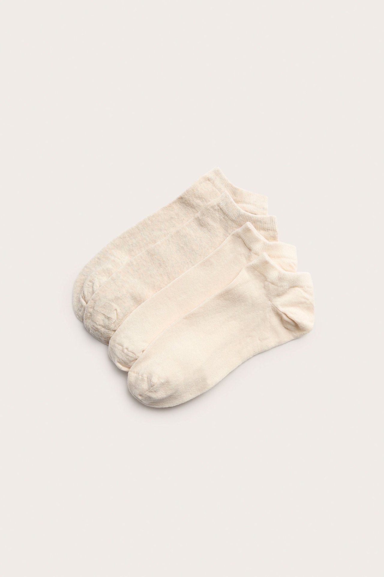 Flat lay av to par beige melert ankelstrømper i bomullsblanding.