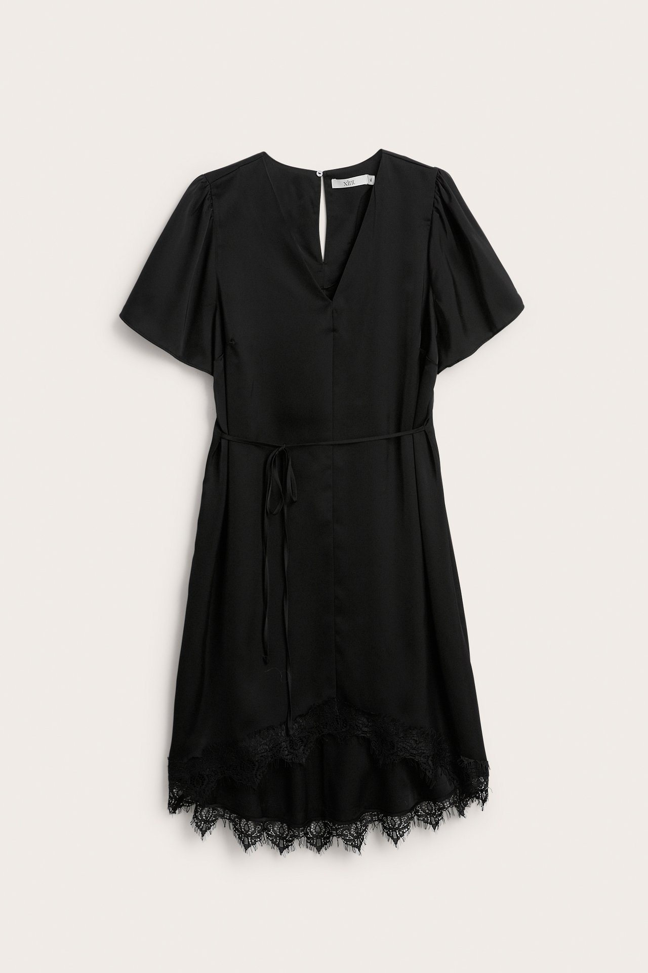 Edestä näkymä mustasta lyhyestä satiinimekosta, jossa V-pääntie, lyhyet hihat, vyötärönauha ja pitsireunus.