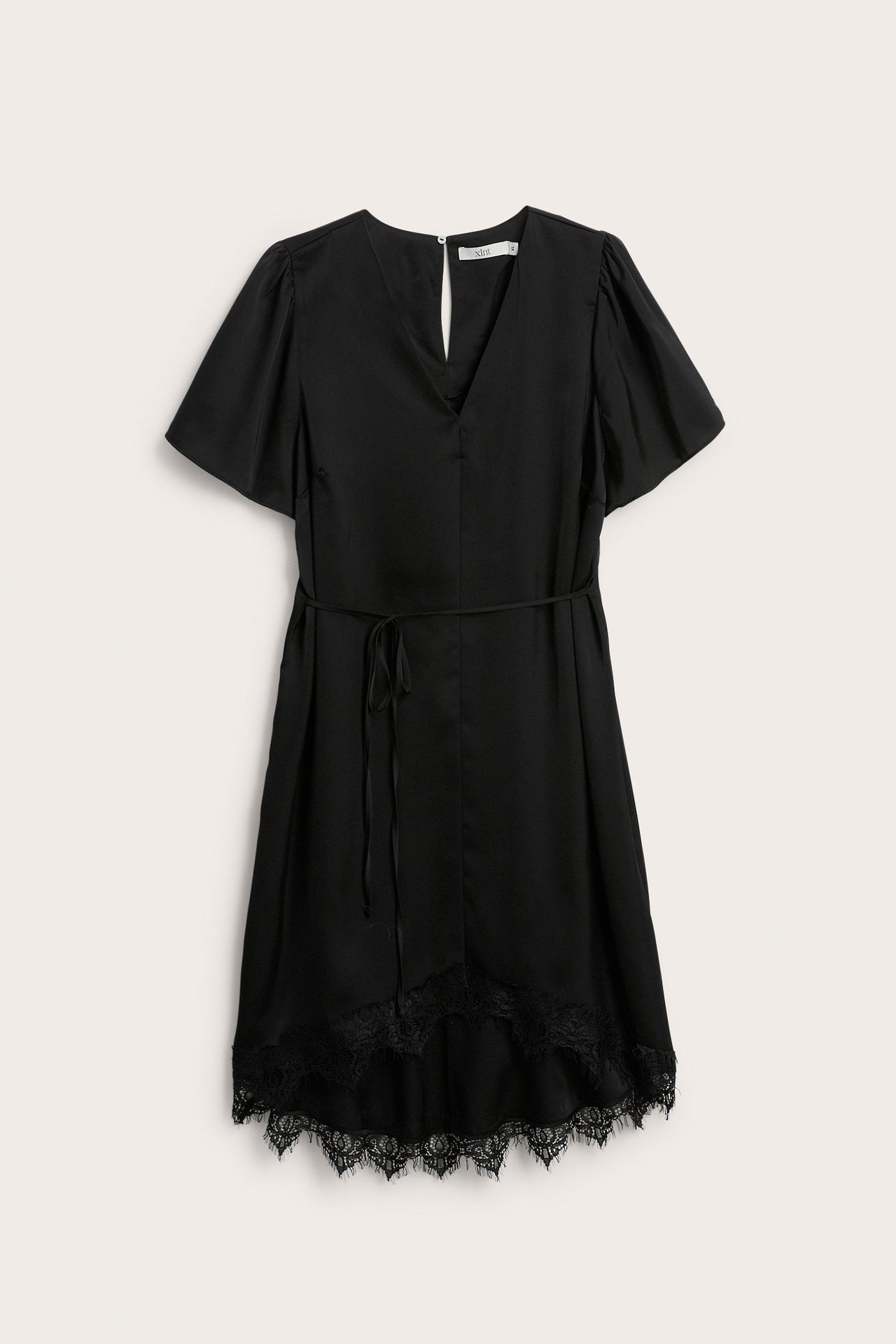 Frontvy av en svart kort satinklänning med V-ringning, korta ärmar, knytband i midjan och spetskant.