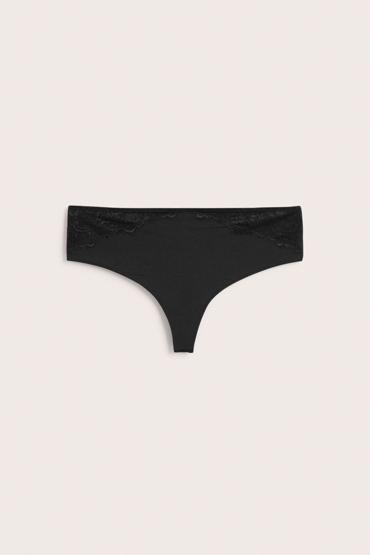 Forfra av svart stringtruse med blondedetaljer på sidene.