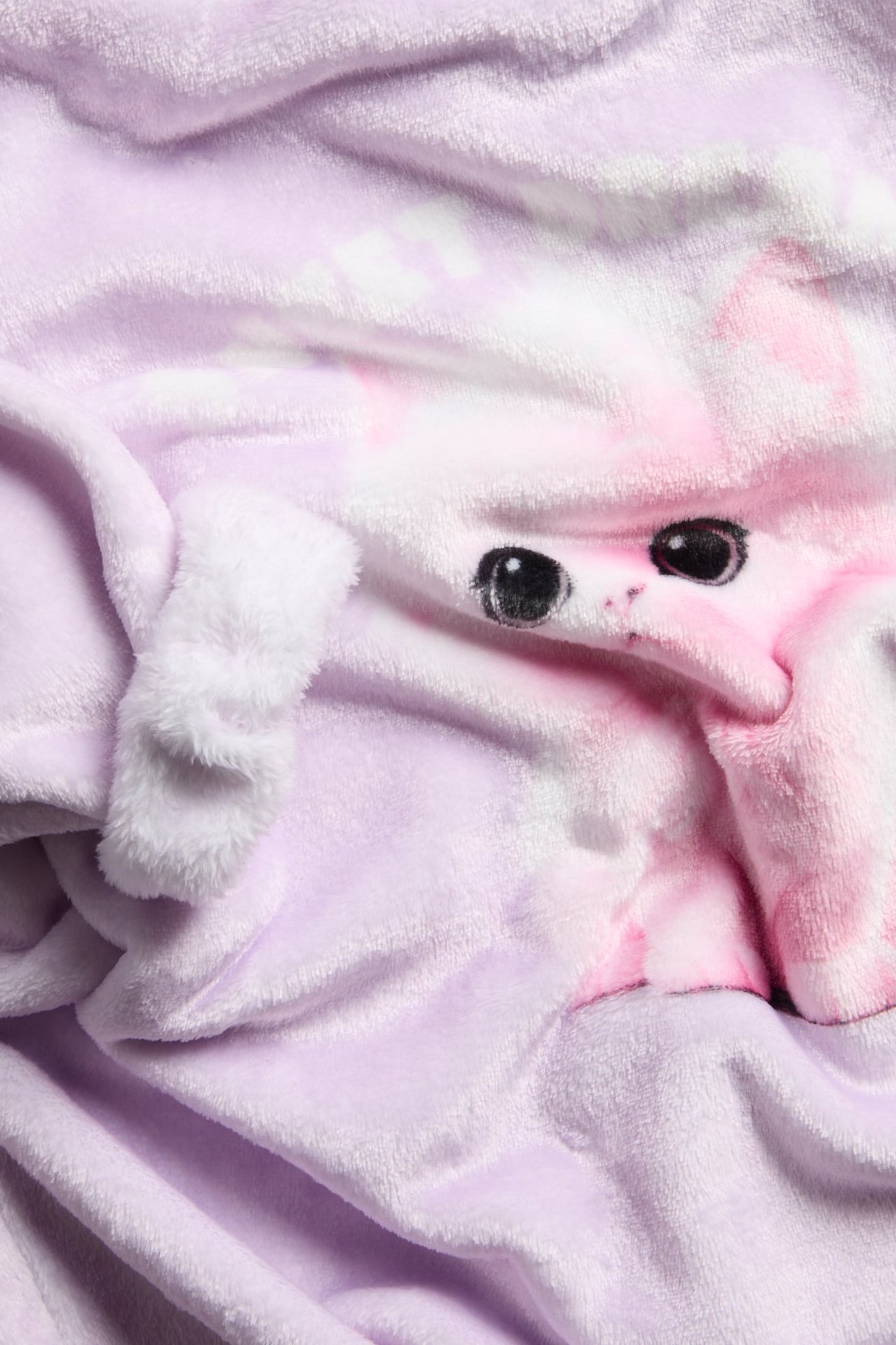 Närbild på en lila och rosa fluffig filt med huva och broderat djuransikte.
