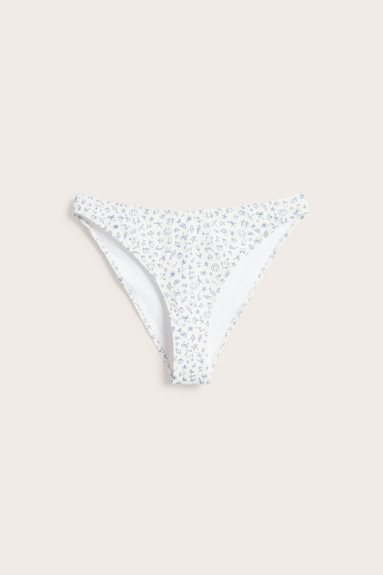 Przód, off-white, V-kształtne figi kąpielowe brazilian z wysokim wycięciem i drobnym, niebieskim wzorem plażowym.