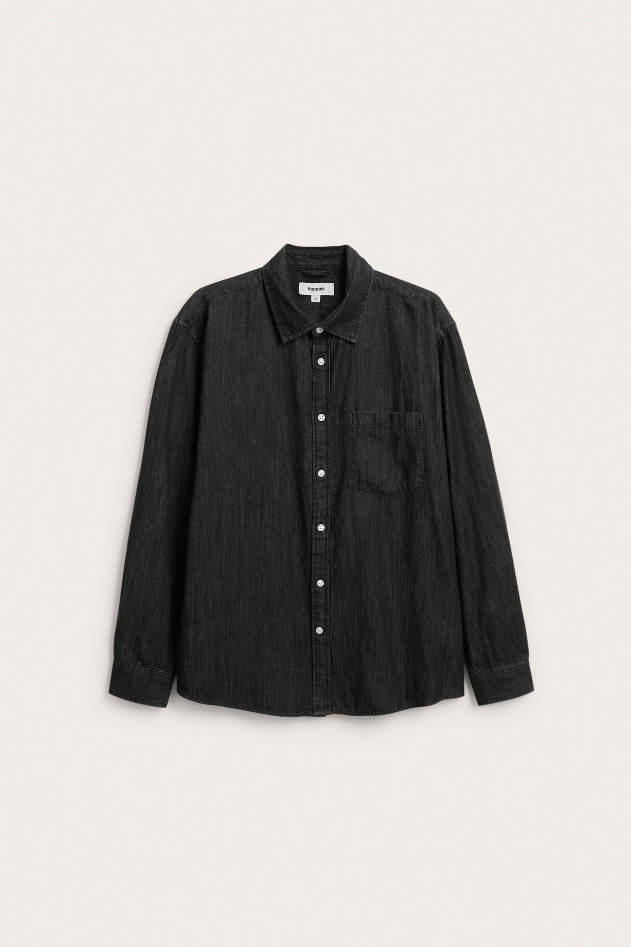 Frontvy av en svart långärmad denimskjorta för män med vita knappar och bröstficka.