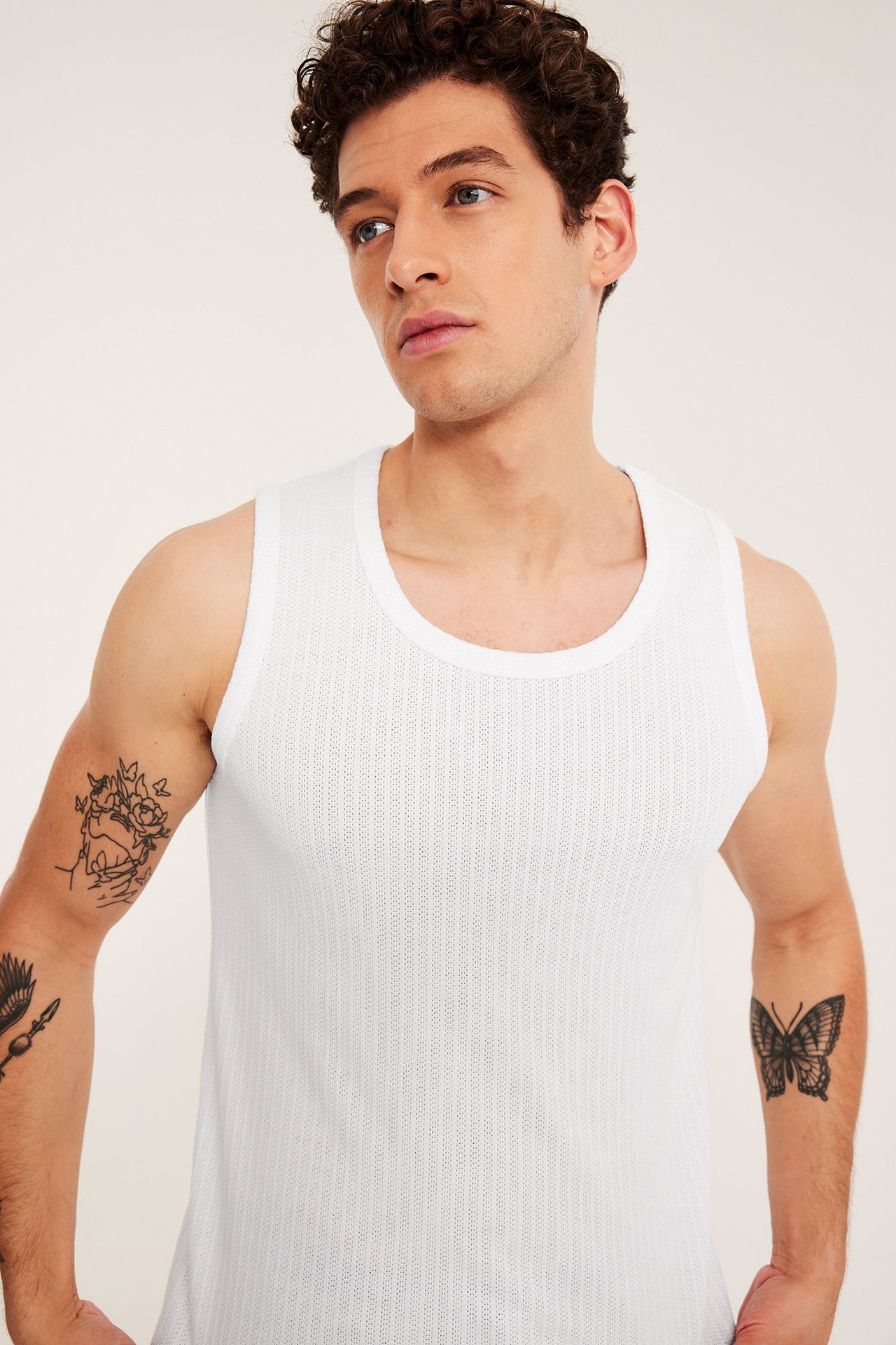 Frontbilde av en mann i en hvit, slim-fit pointelle jacquard singlet.