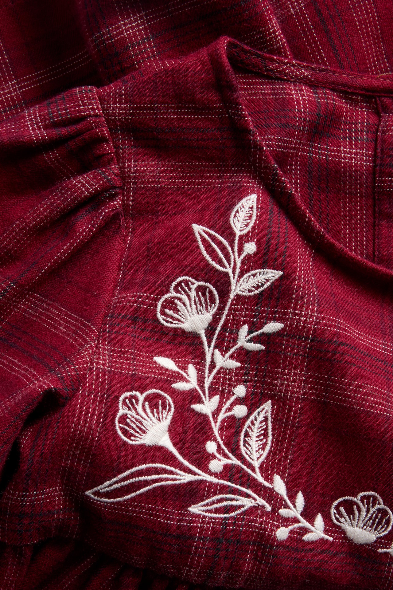 Ruudullinen kudottu joulumekko, jossa on pitsiä