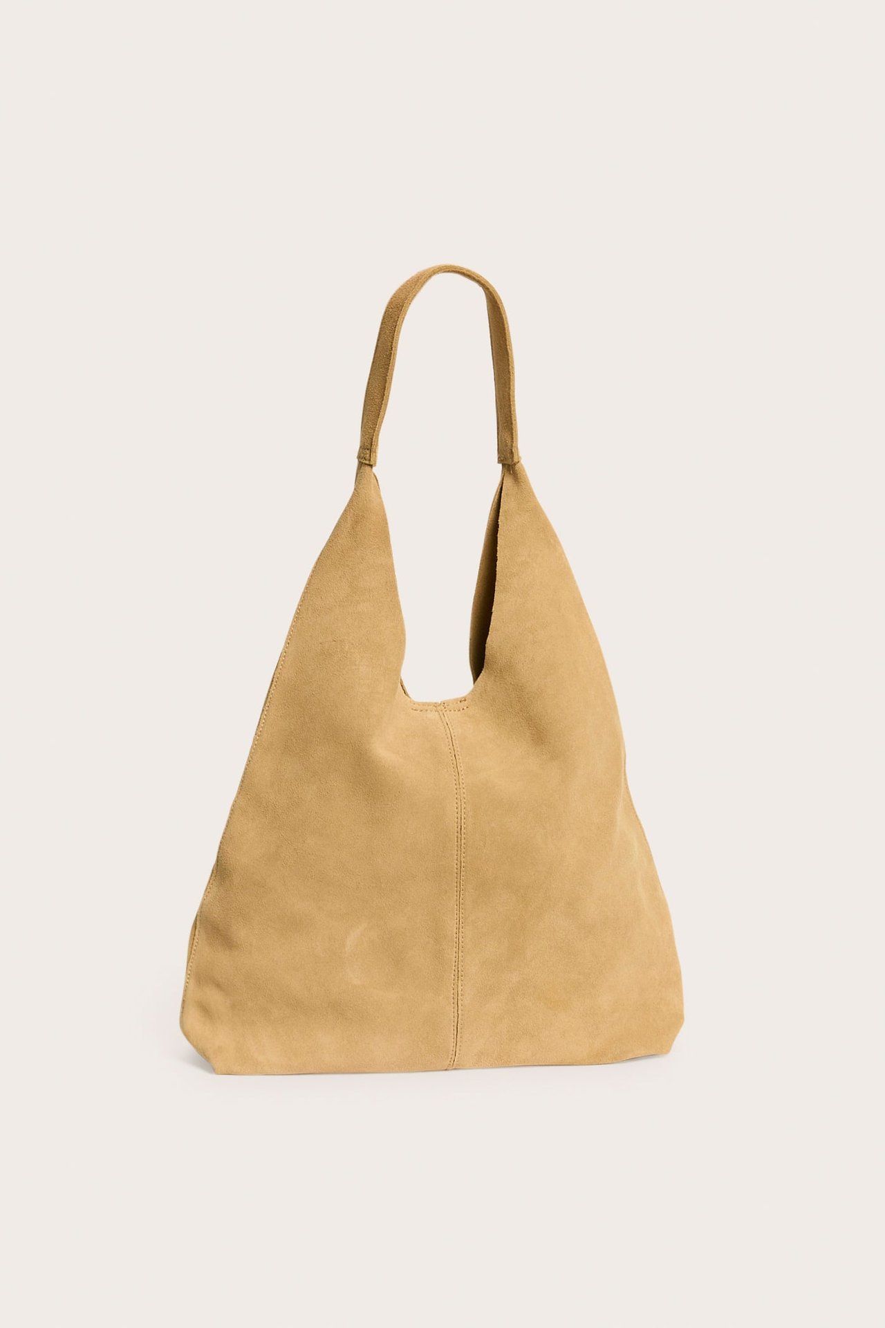 Front av en beige semsket skinn hobo-veske med ett enkelt håndtak.
