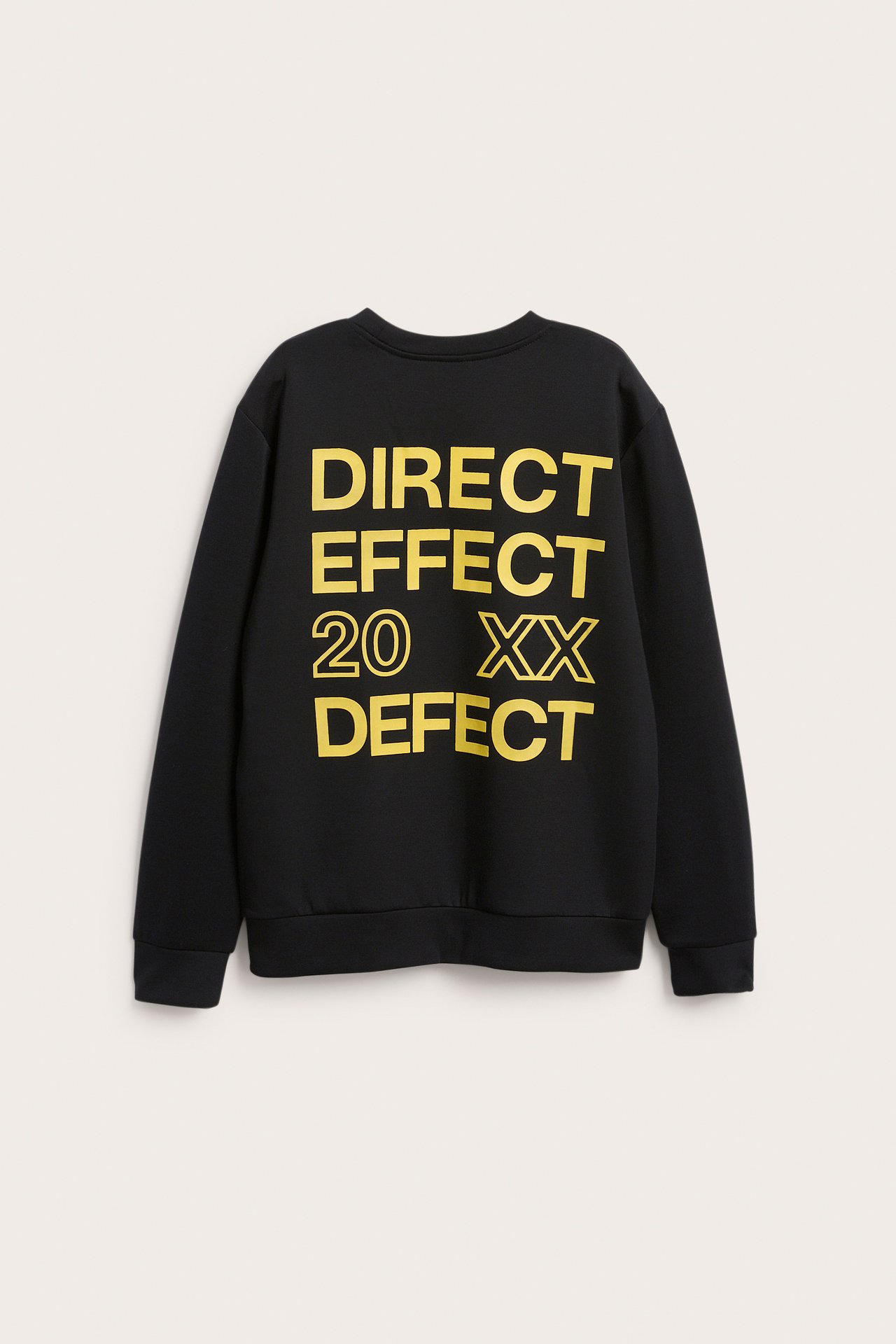 Baksida av en svart tröja med gult texttryck 'DIRECT EFFECT 20 XX DEFECT'.