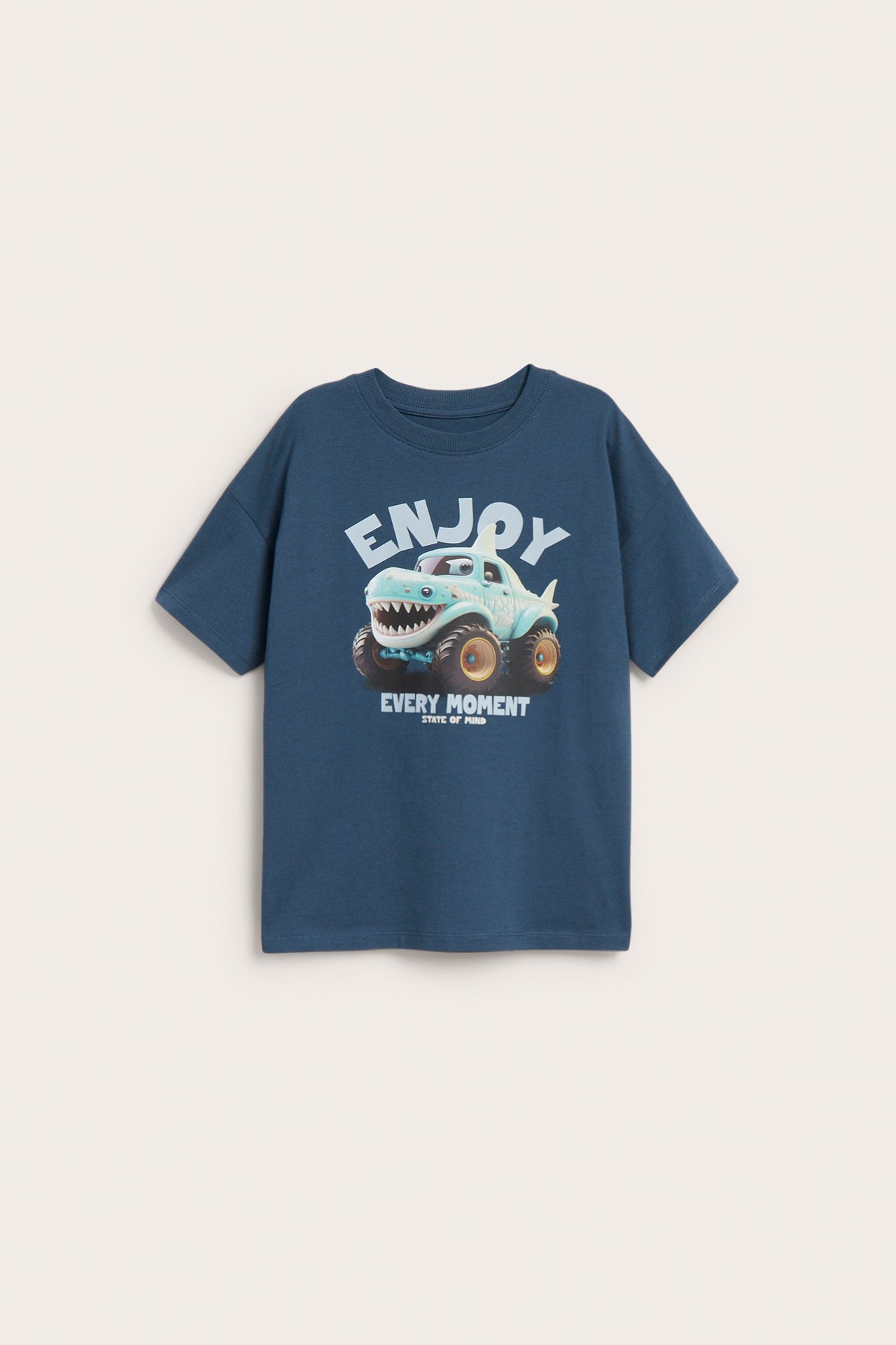 Frontvy: Barns blåa bomullst-shirt med haj-monstertrucktryck, 'Enjoy Every Moment'.