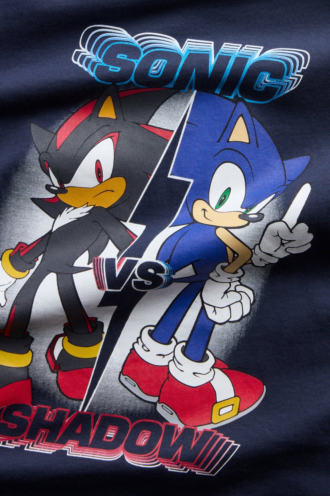 Zbliżenie granatowego t-shirtu z nadrukiem graficznym Sonic i Shadow.