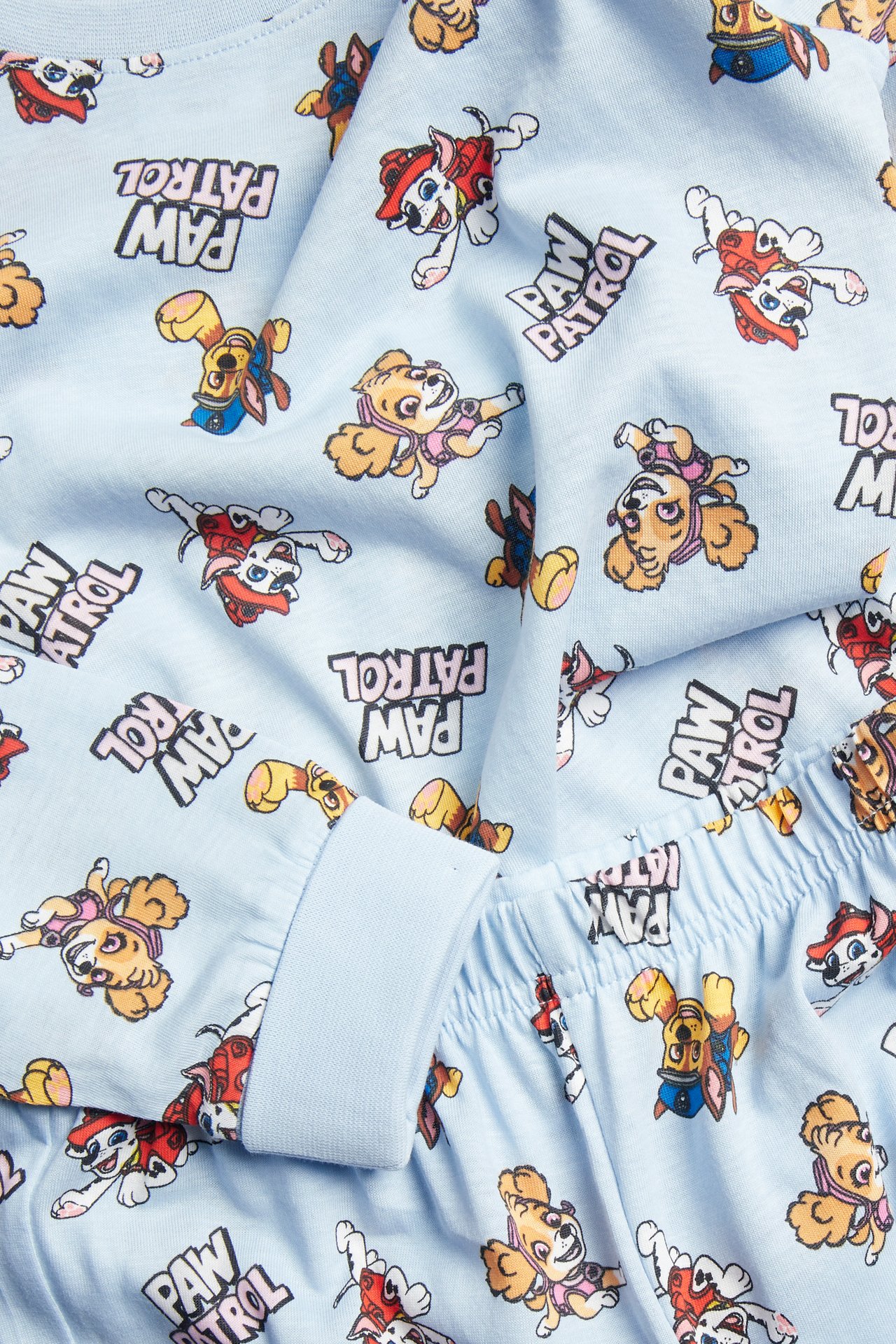 Närbild av ljusblå Paw Patrol-pyjamas för barn med resårmuddar och midja.