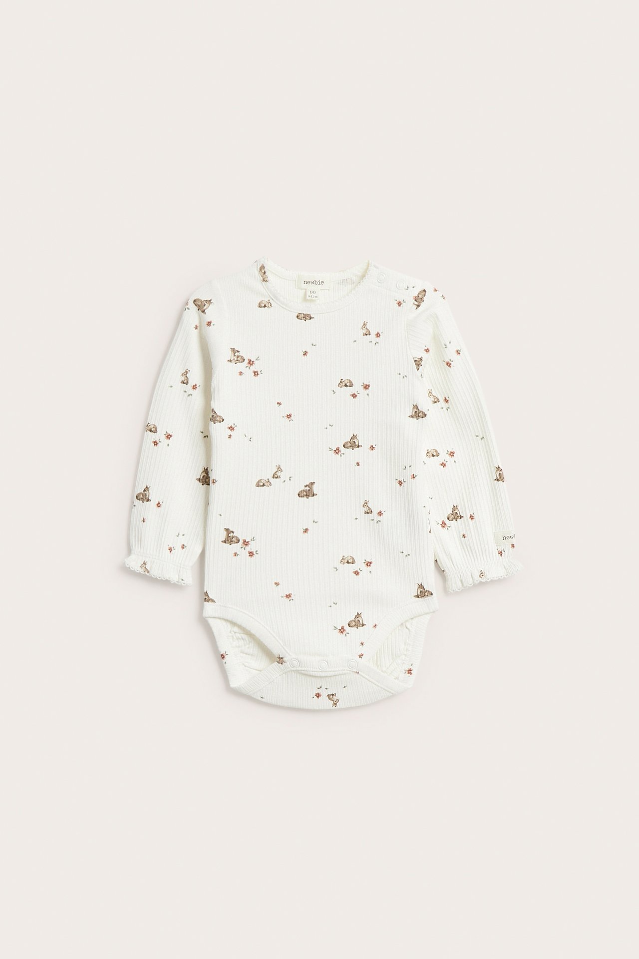 Frontbilde av en offwhite ribbet babybody med rådyr- og blomstermønster, picotkanter og håndleddsfolder.