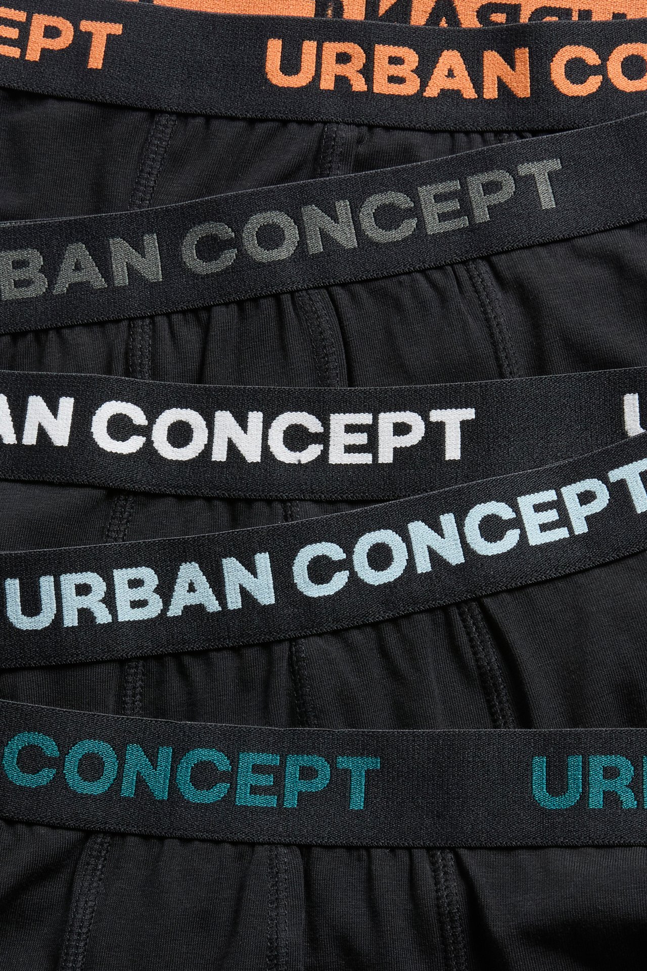 Nærbilde av svarte bokserbriefs med 'URBAN CONCEPT' trykte linninger i flere farger.