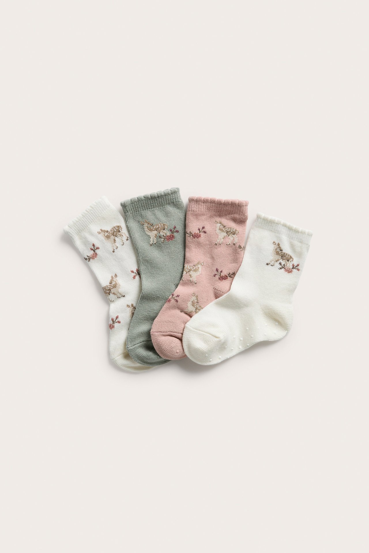 Fyra par babysockor: offwhite, salviagrön och rosa, alla med rådjurs- och blommönster.