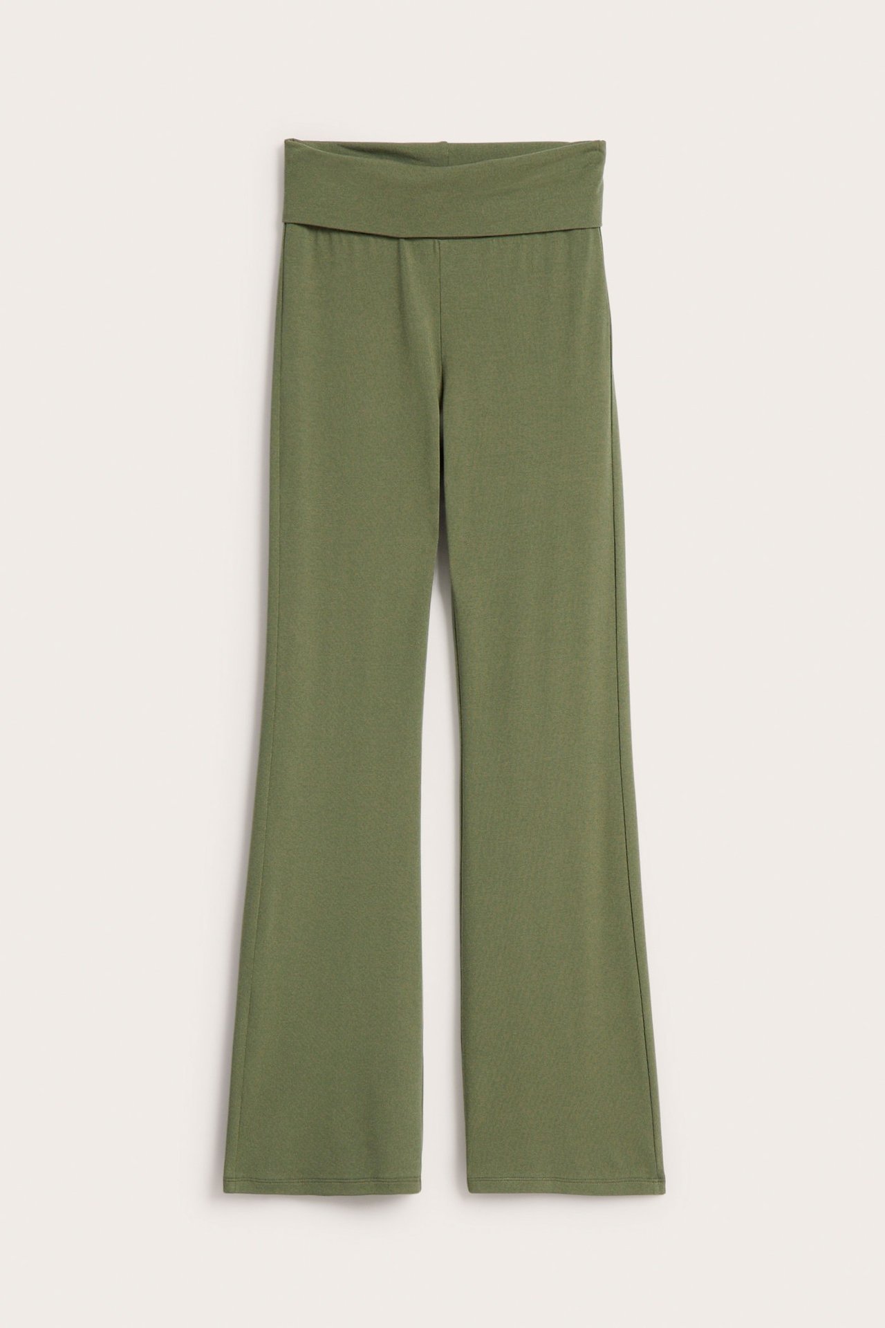 Frontvy av enfärgade mörkgröna utsvängda leggings med bekväm nedfällbar midja.