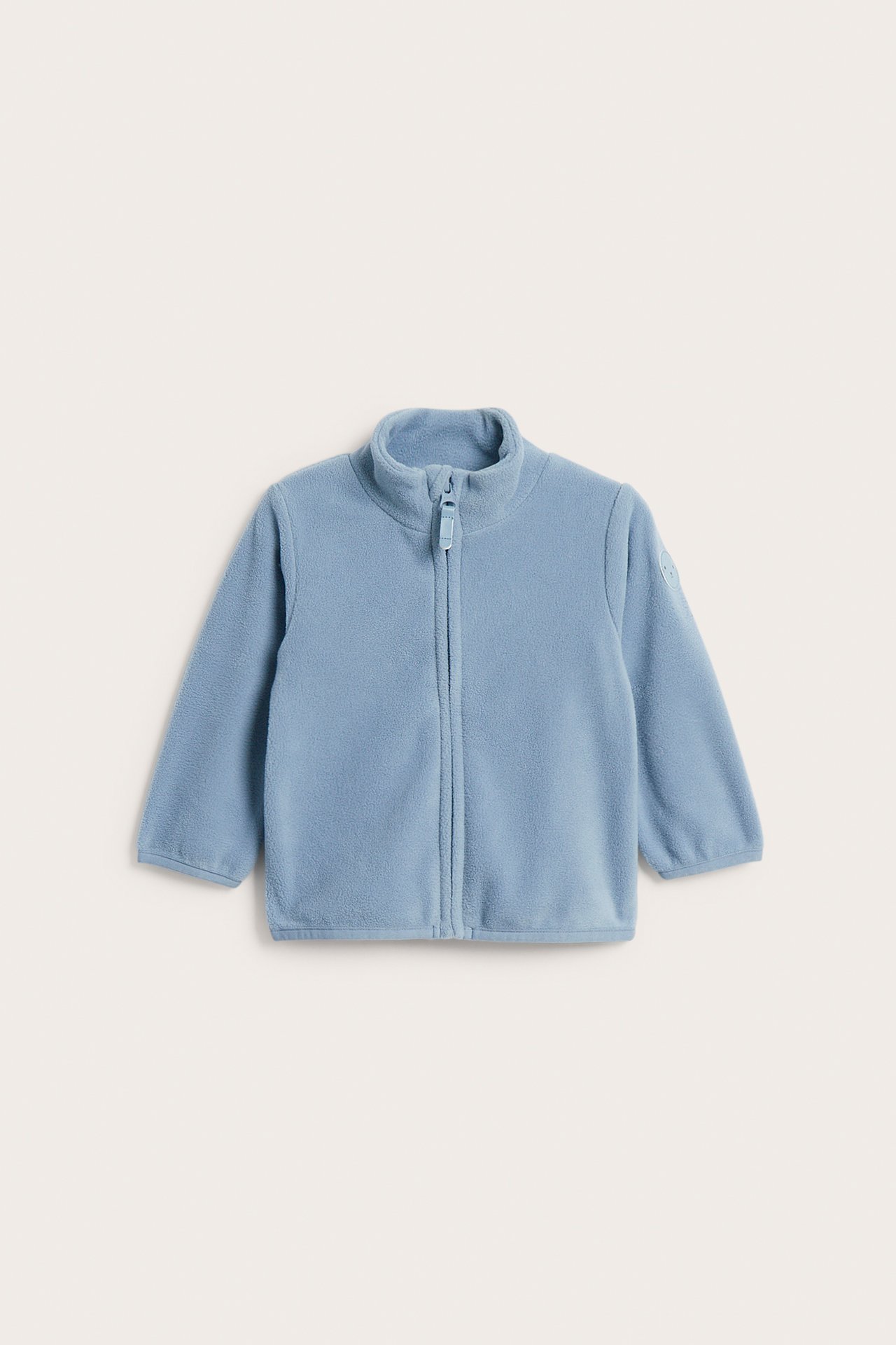 Edestä vauvan vaaleansininen fleece-vetoketjutakki pystykauluksella.