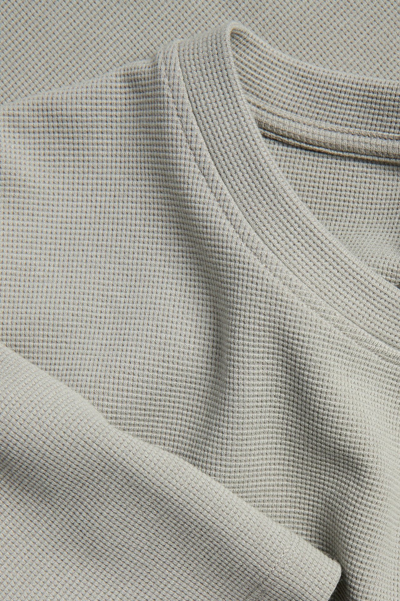 Nærbilde av en lysegrønn vaffelmønstret T-skjorte for herre med rund hals.