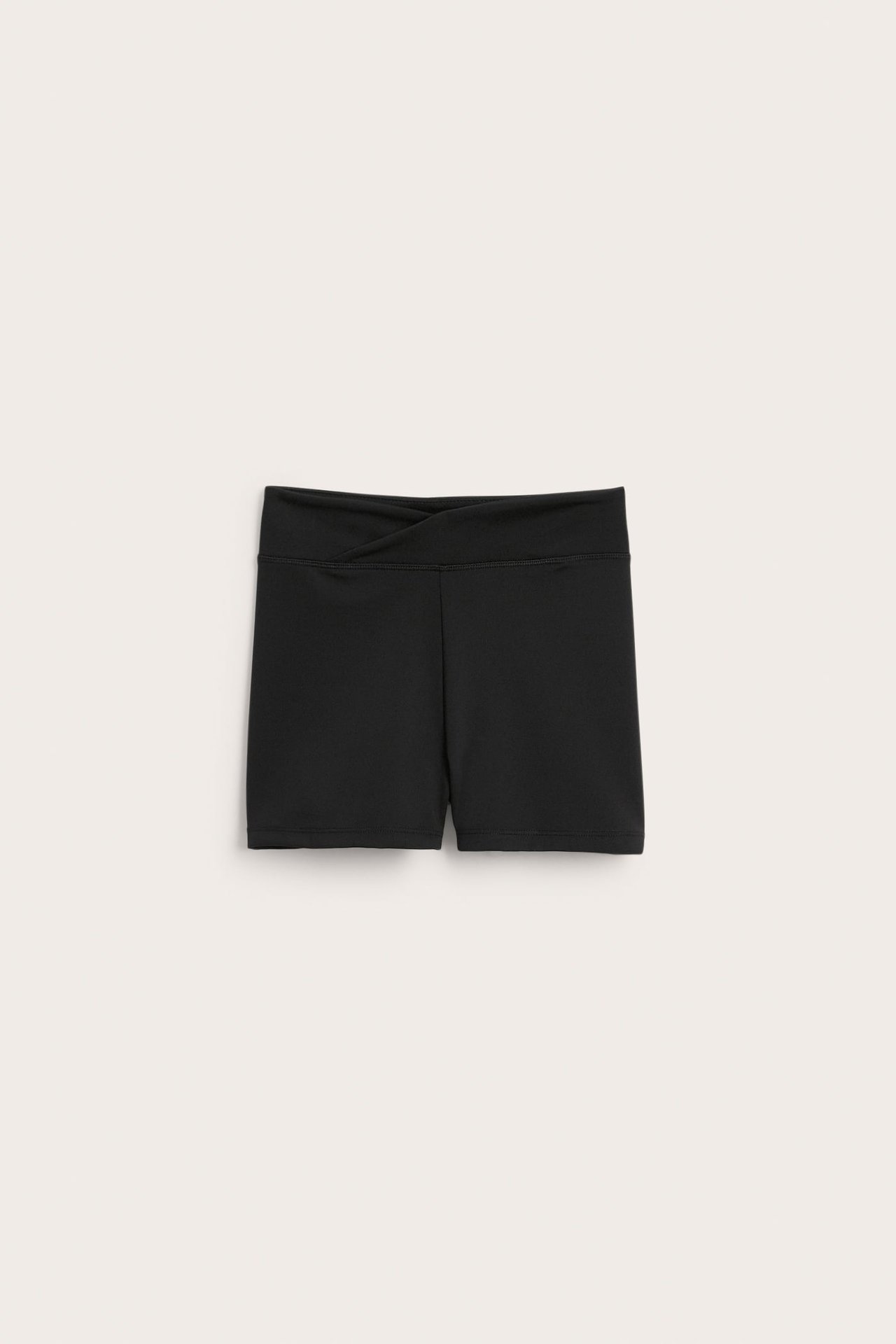 Framifrån, svarta träningsshorts med omlott elastisk linning.