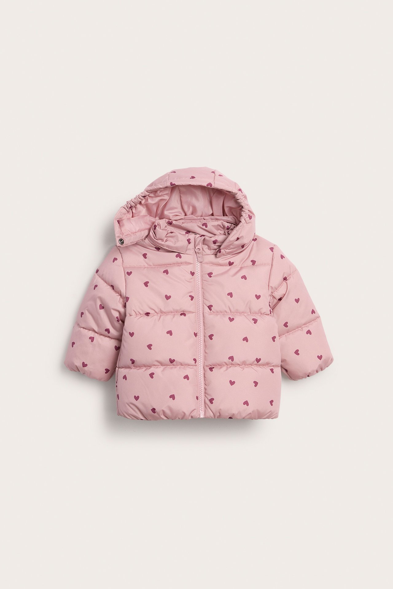 Framifrån: Rosa babyjacka med huva, puffig design, mörka hjärtan och dragkedja.