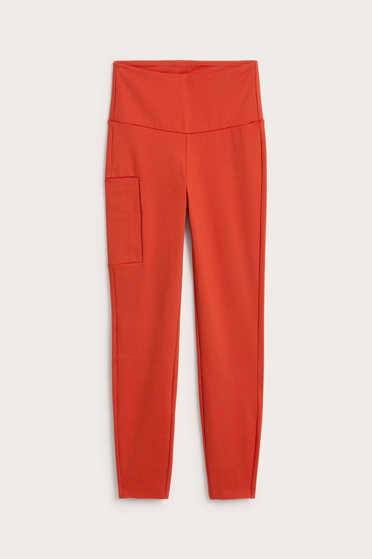Framsida av orange högmidjade damtights med en cargoficka.