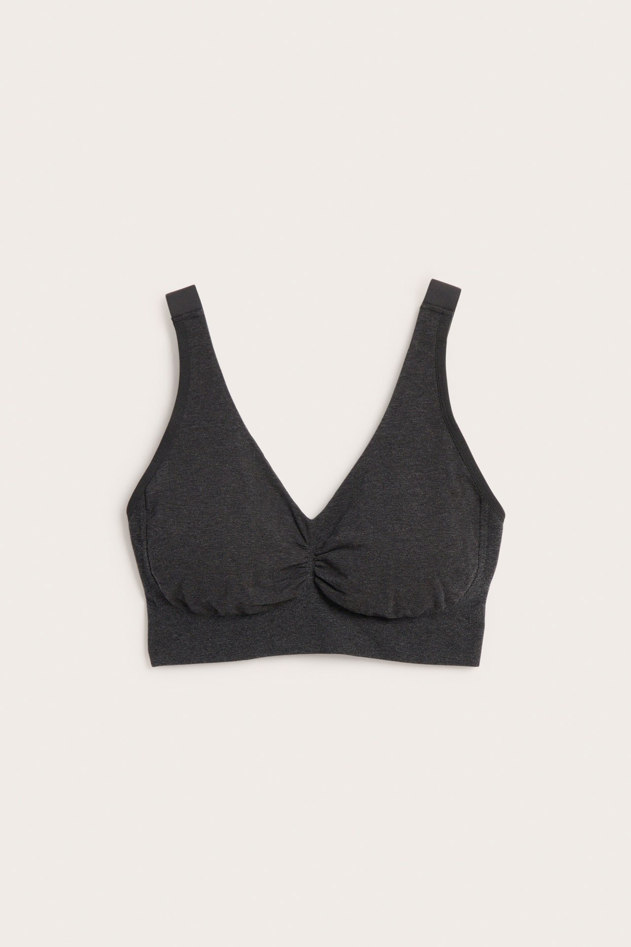 Framifrån: en mörkgrå sömlös V-ringad bralette med rynkdetalj.