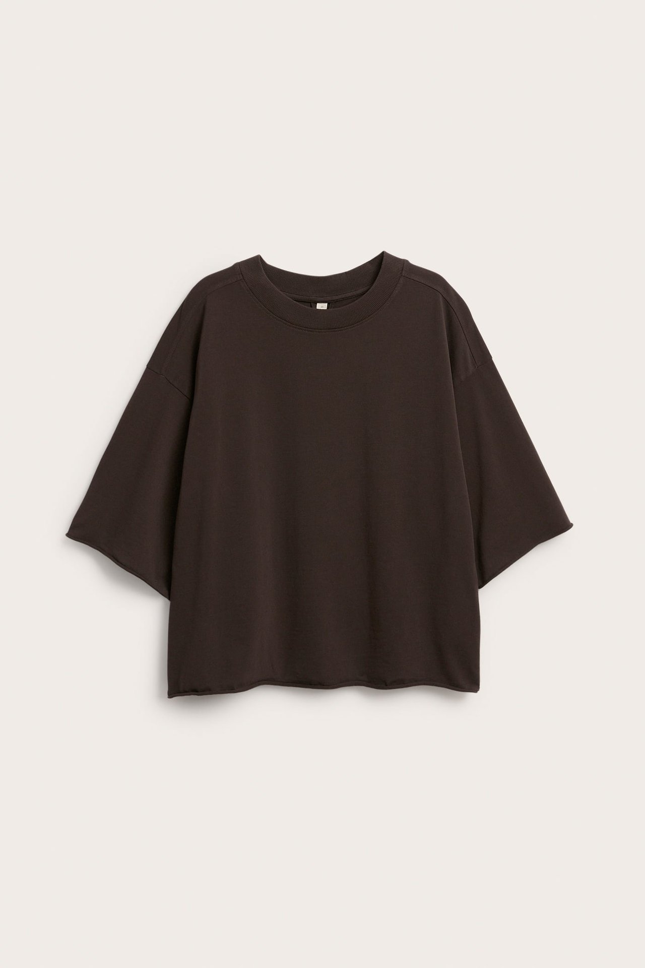 Framifrån mörkbrun avslappnad kortärmad t-shirt med rund hals och rå kant.