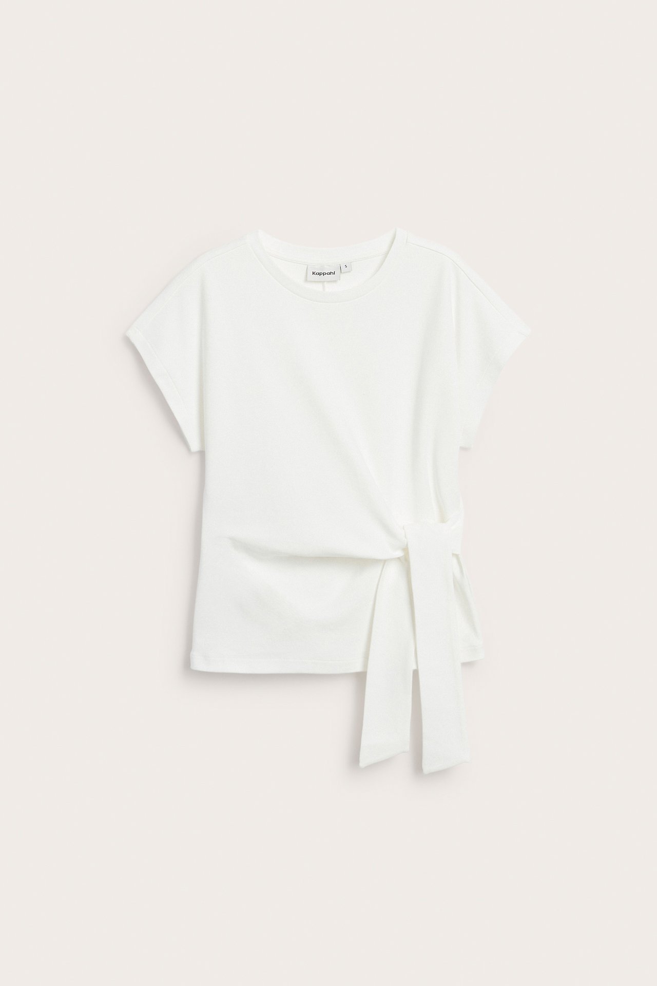 Edestäpäin: luonnonvalkoinen lyhythihainen puuvillatoppi, jossa koristeellinen solmuyksityiskohta vyötäröllä.