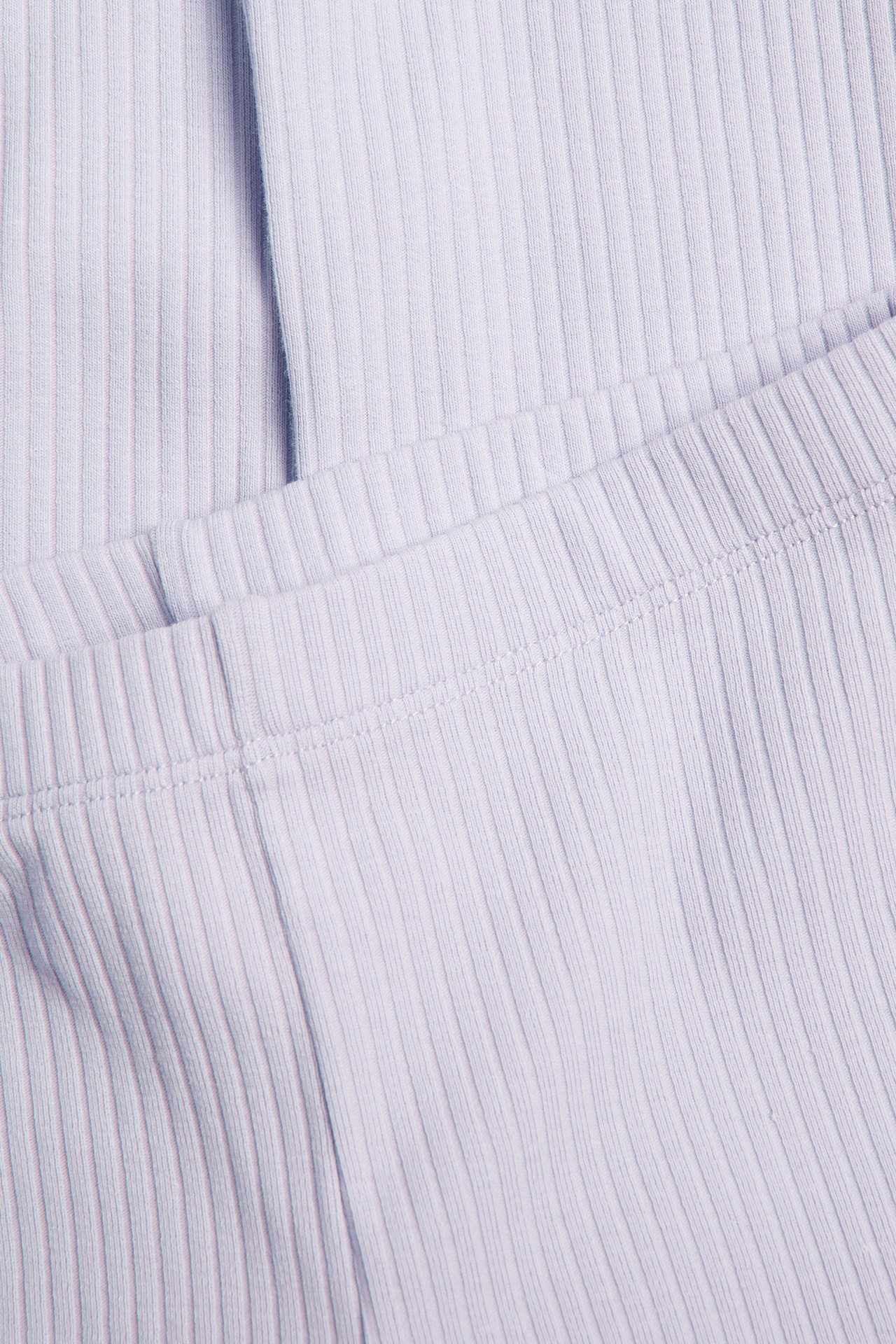 Lähikuva vaaleanliiloista ribbineuleleggingseistä joustavalla vyötäröllä.