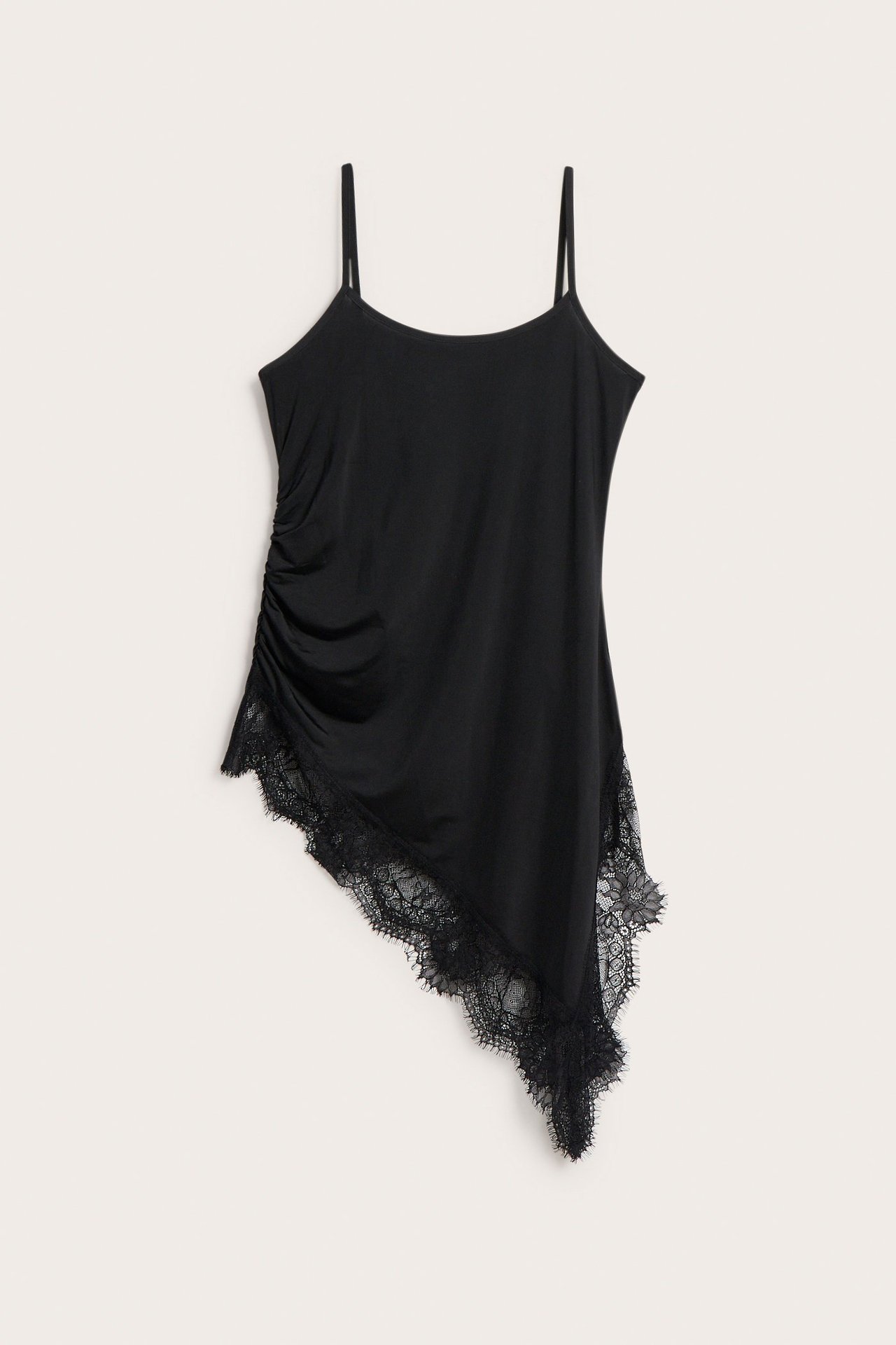 Forfra: Svart lang asymmetrisk camisole med spaghettistropper, rynker i siden og blondekant.
