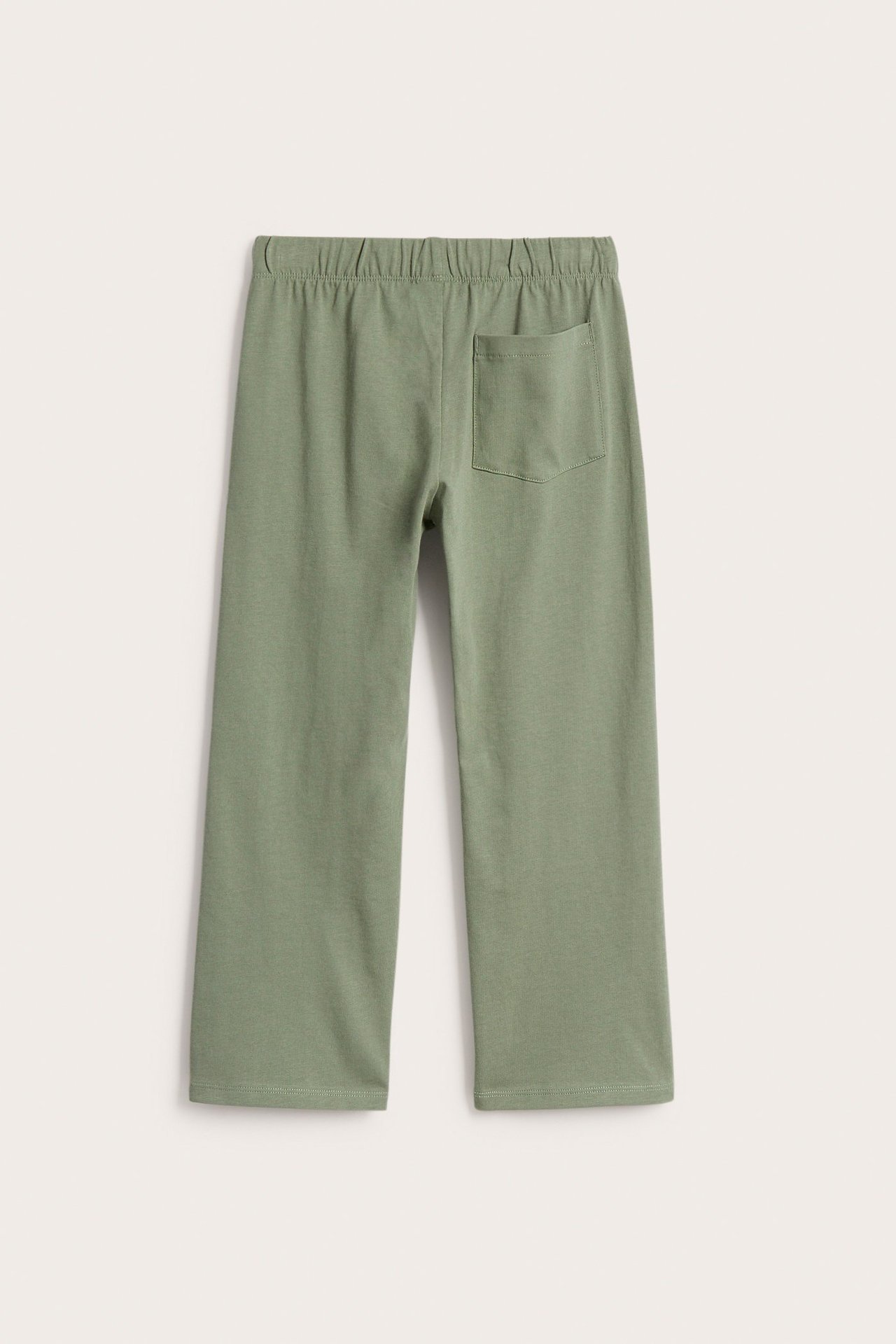 Takakuva: Tummanvihreät lasten puuvillatrikoo-collegehousut, suoralahkeiset, joustovyötärö ja takatasku.