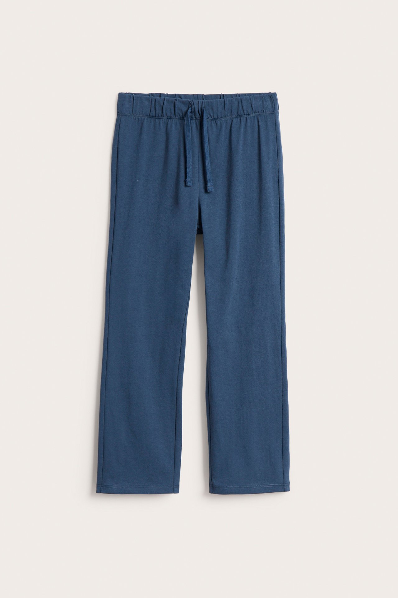 Edestä: Siniset puuvillaiset collegehousut suorilla lahkeilla ja kiristysnyörillä vyötäröllä.