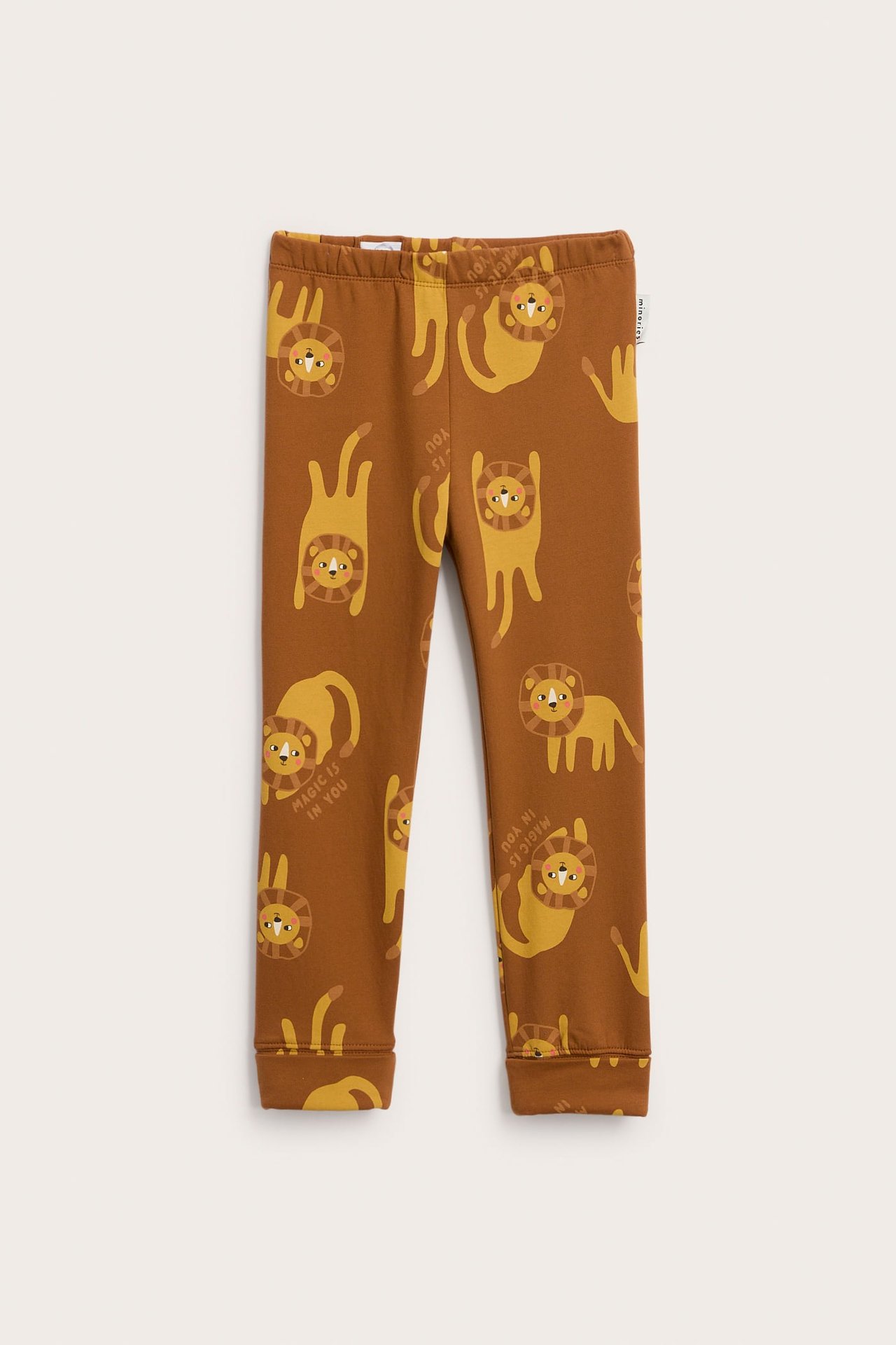 Front av barneleggings i brunt med lekent løvemønster.