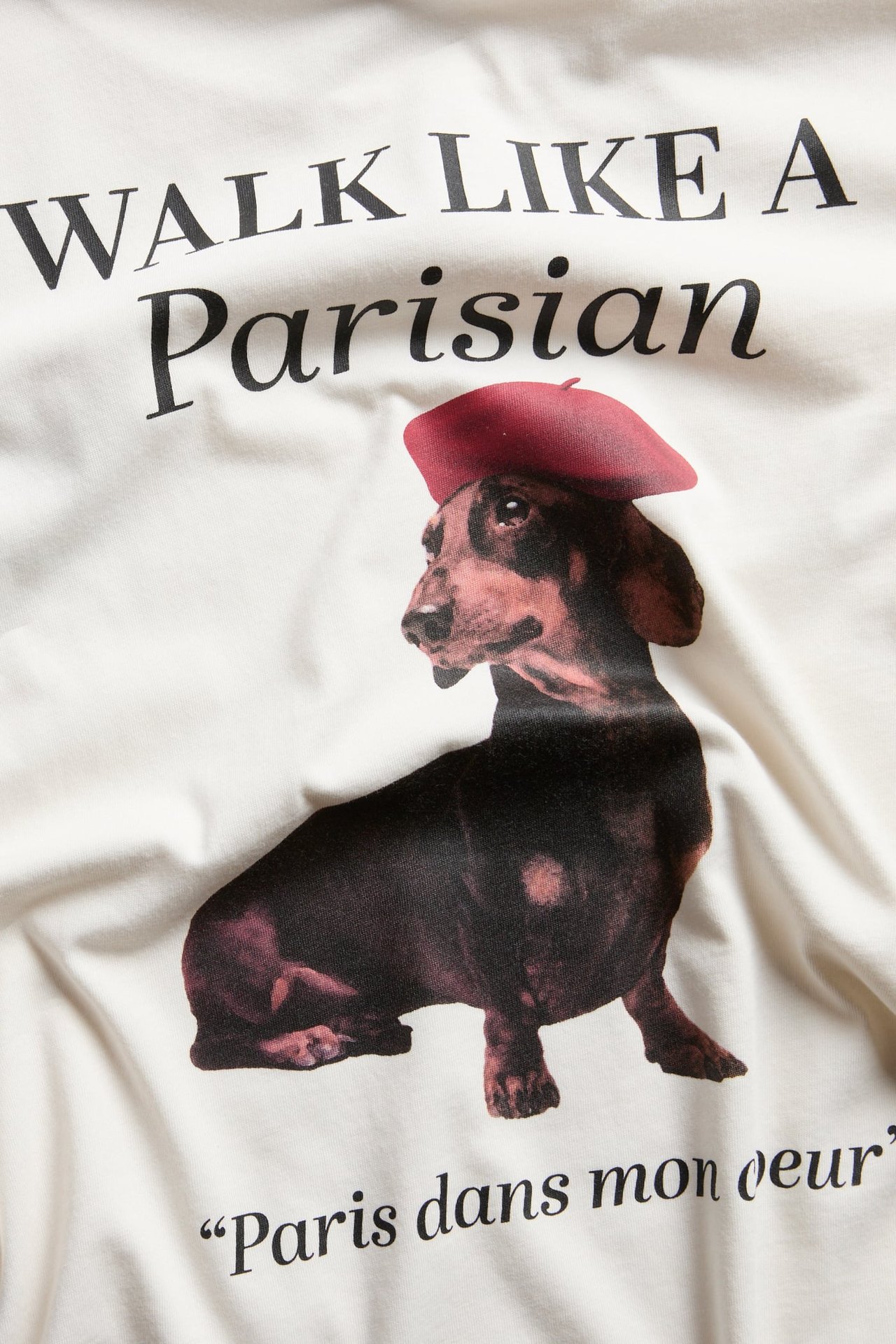 Biała bawełniana koszulka z nadrukiem: jamnik w czerwonym berecie i "WALK LIKE A Parisian".