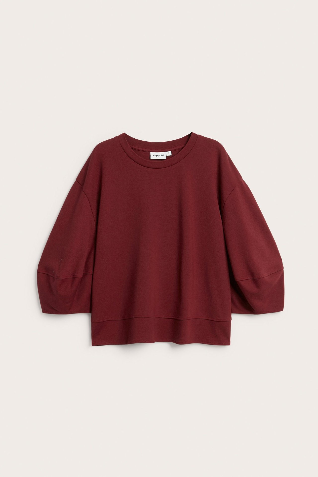 Edestäpäin kuvattu löysä tummanpunainen punto-toppi, jossa pyöreä pääntie ja 3/4-pitkät pussihihat.