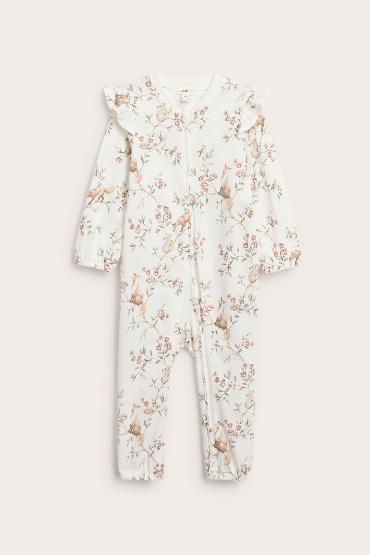 Edestä: Luonnonvalkoiset puuvillavauvanpyjamat metsäeläinprintillä, röyhelöillä, joustavilla hihansuilla ja vetoketjulla.