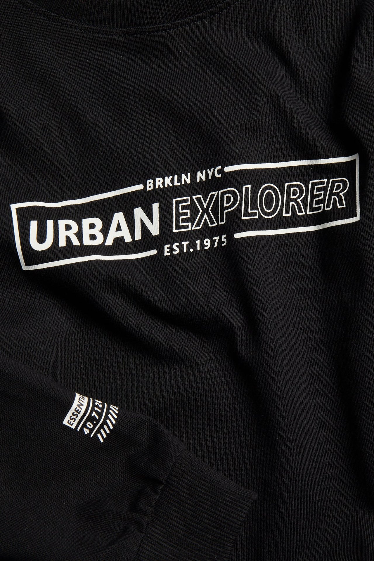 Widok z przodu czarnej bawełnianej bluzy z białym napisem "Urban Explorer".
