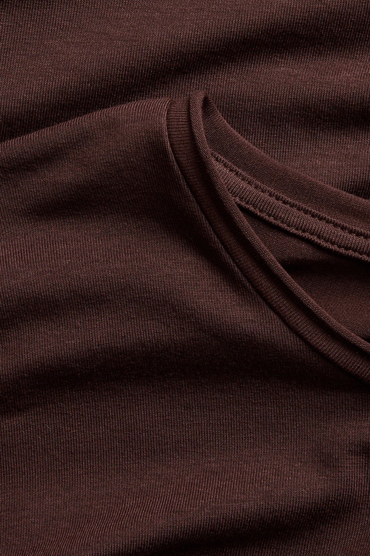 Lähikuva tummanruskeasta ribbineulepaidasta, jossa kauluksen yksityiskohta.