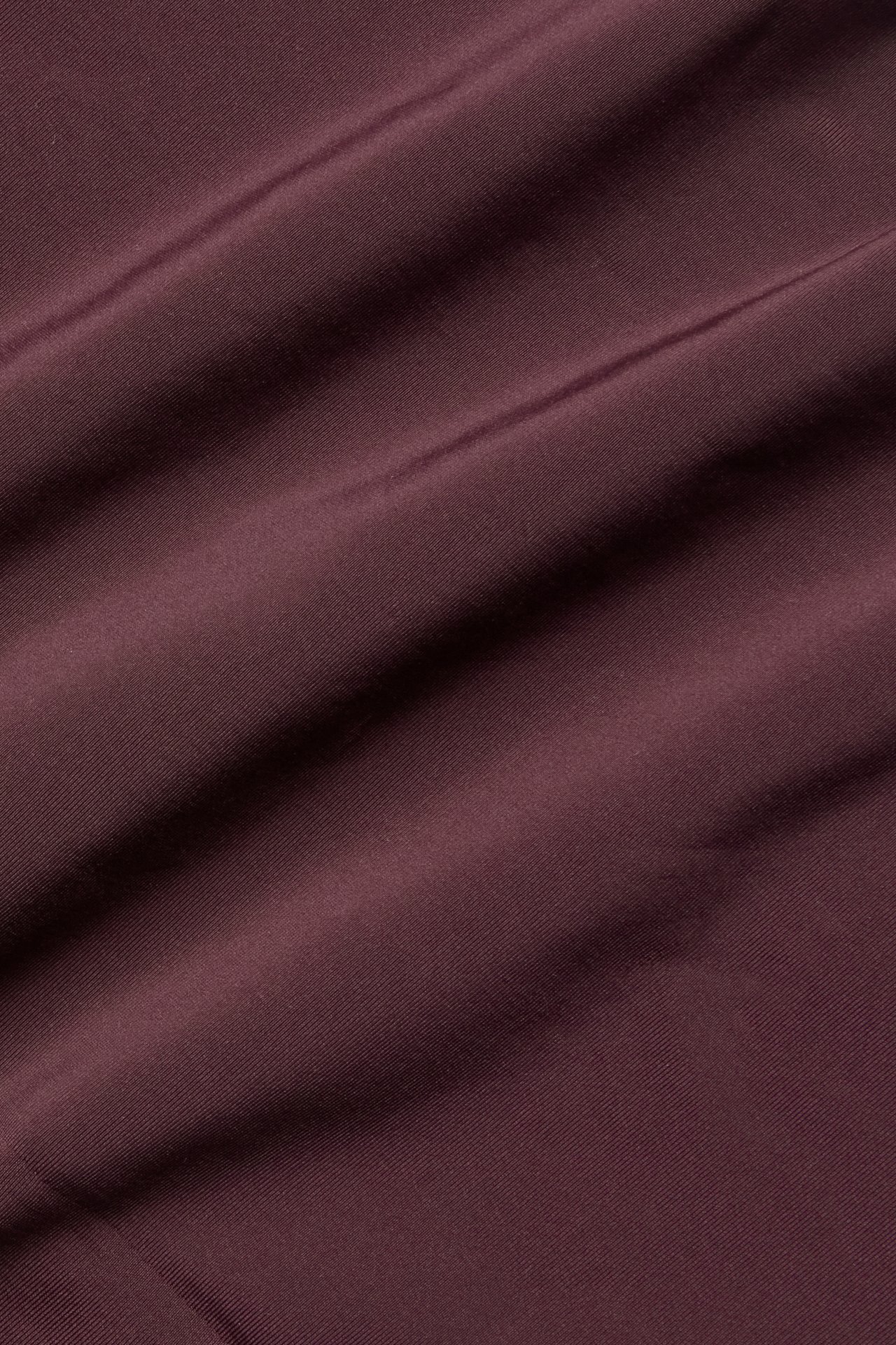 Närbild på draperat vinrött tyg.