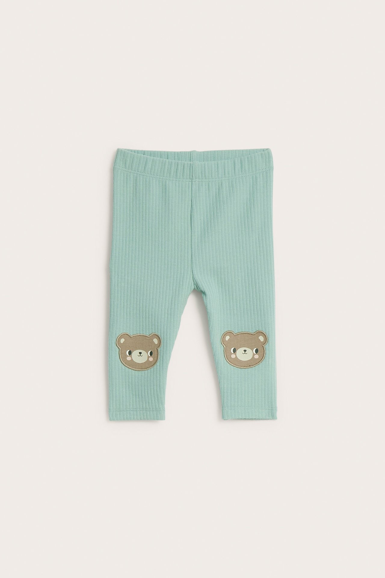 Widok z przodu: turkusowe, prążkowane legginsy dziecięce z aplikacjami misiów na kolanach.