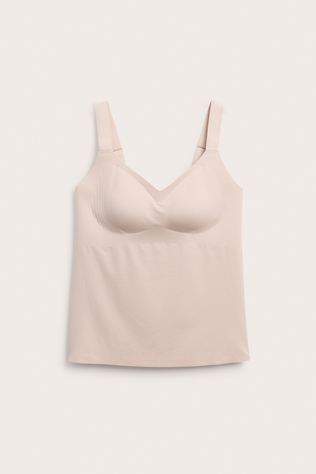 Framifrån, ljusbeige sömlös damtopp med inbyggd bh.
