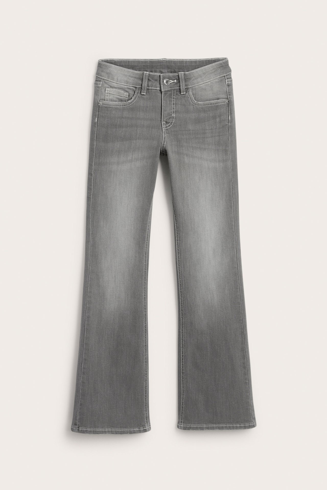 Frontvy av gråa utsvängda denimjeans med knapp och dragkedja.