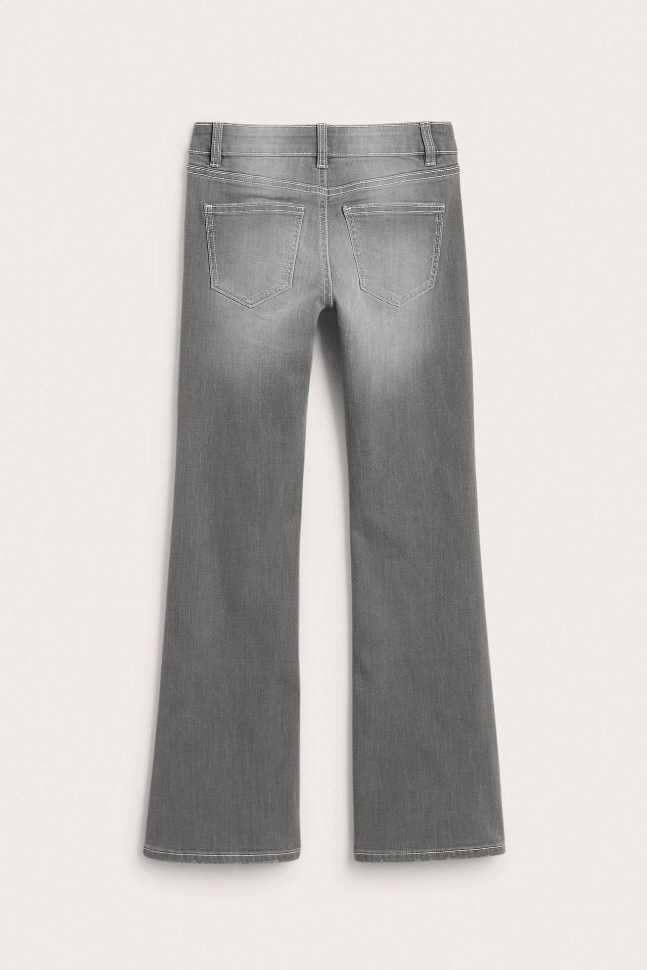 Bakifrån av grå utsvängda jeans med två bakfickor och hällor.