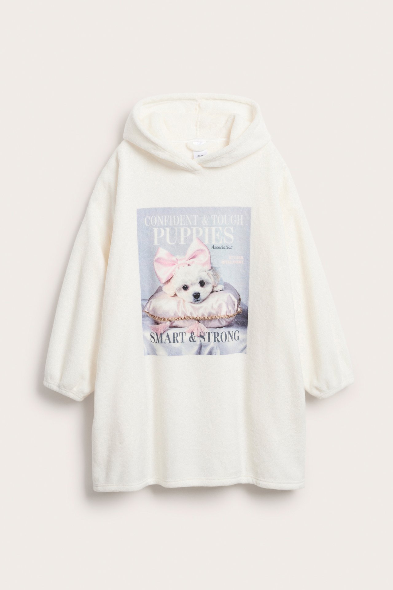 Framifrån: Lång offwhite fleecehoodie med huva och ett färgglatt valptryck på magen.