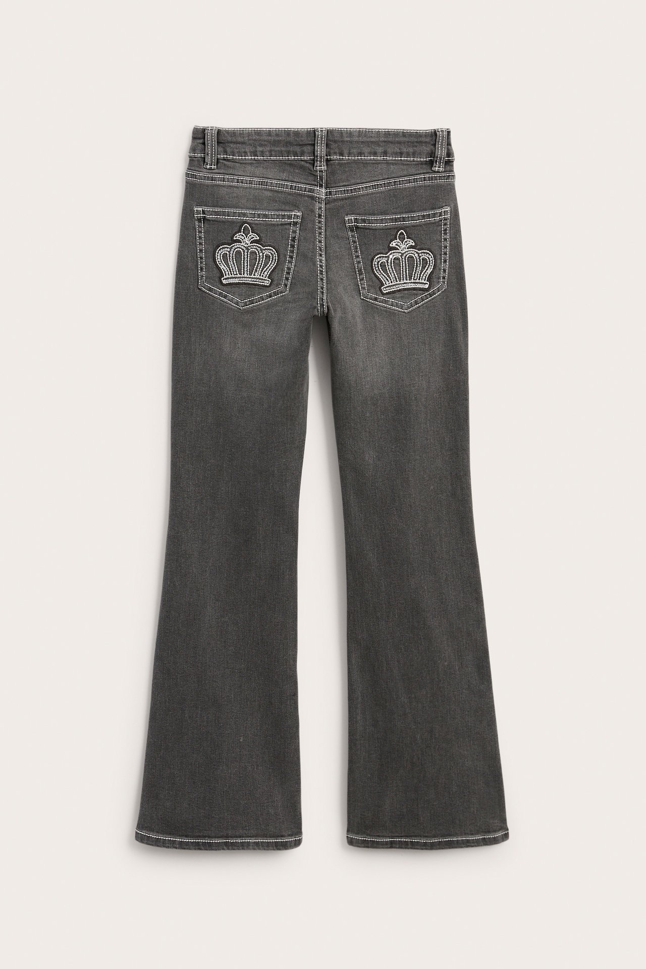 Takakuva tummanharmaista bootcut-farkuista, joissa kruunukirjonta takataskuissa.