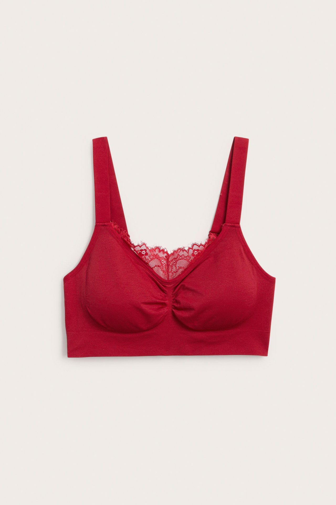Frontvy av en röd sömlös bralette med spetsdetalj och rynkade kupor.