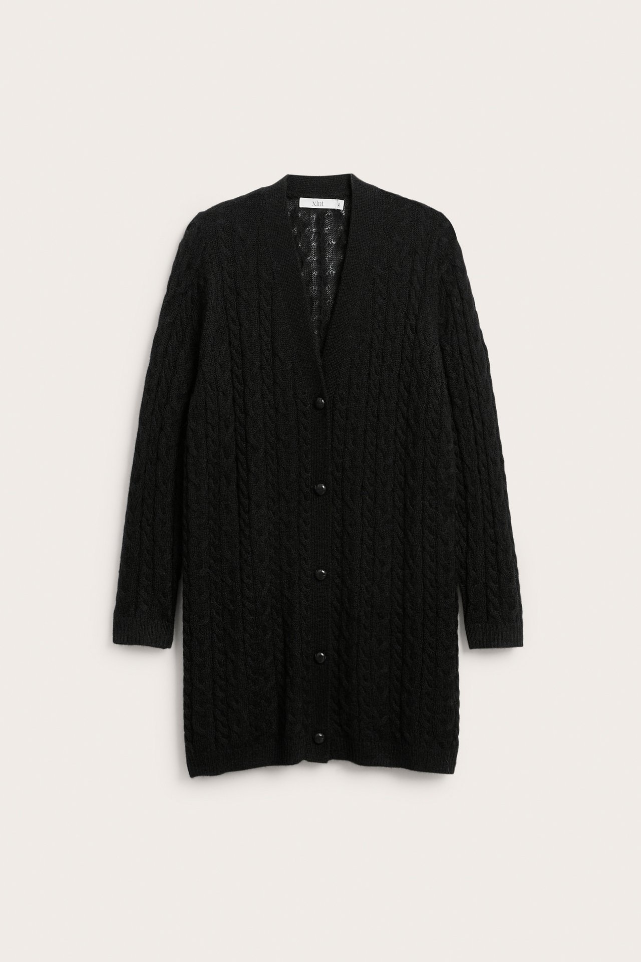 Front av en svart kabelstrikket lang cardigan med knapper.