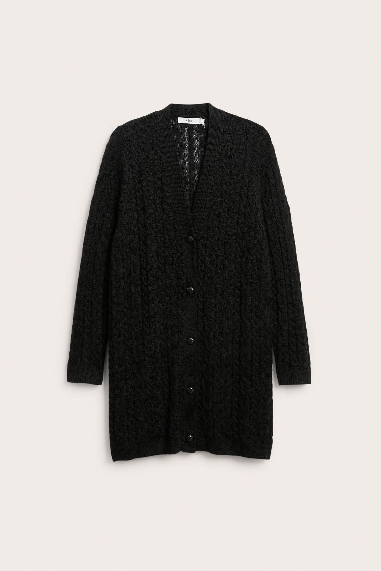 Front av en svart kabelstrikket lang cardigan med knapper.
