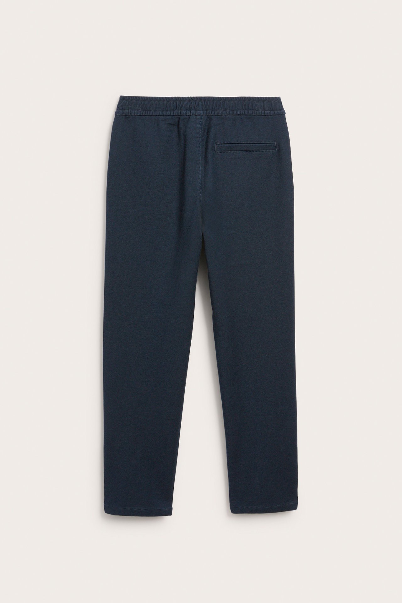 Bakfra av mørkeblå ensfargede joggebukse med elastisk linning og en baklomme.